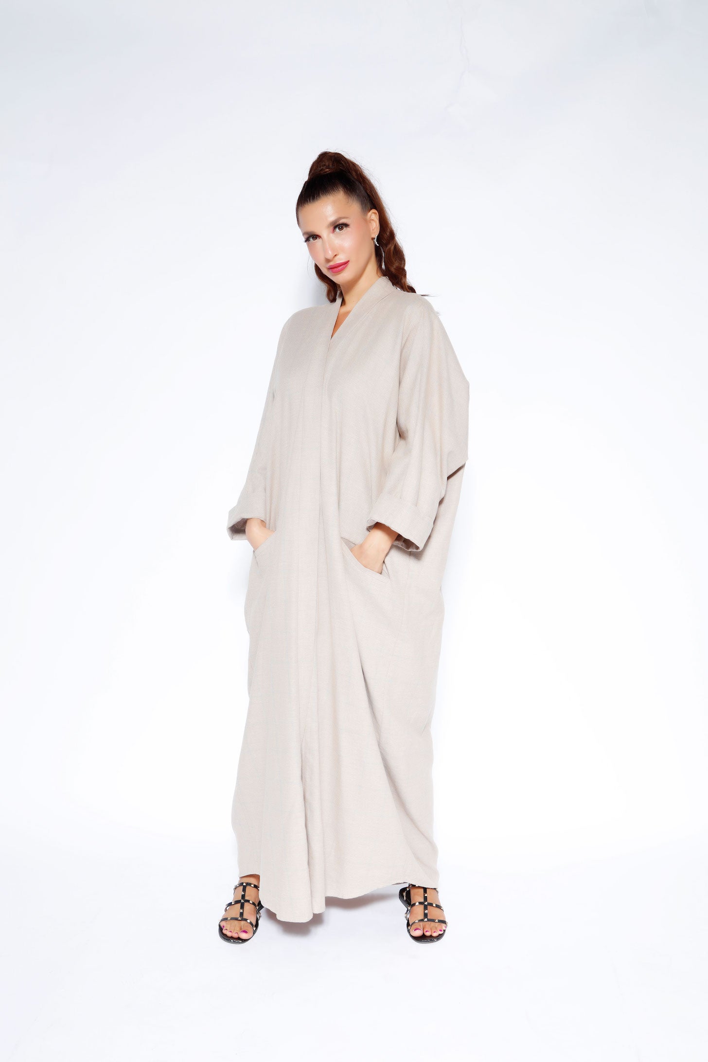 Beige linen abaya featuring an open-front style with front slit pockets
